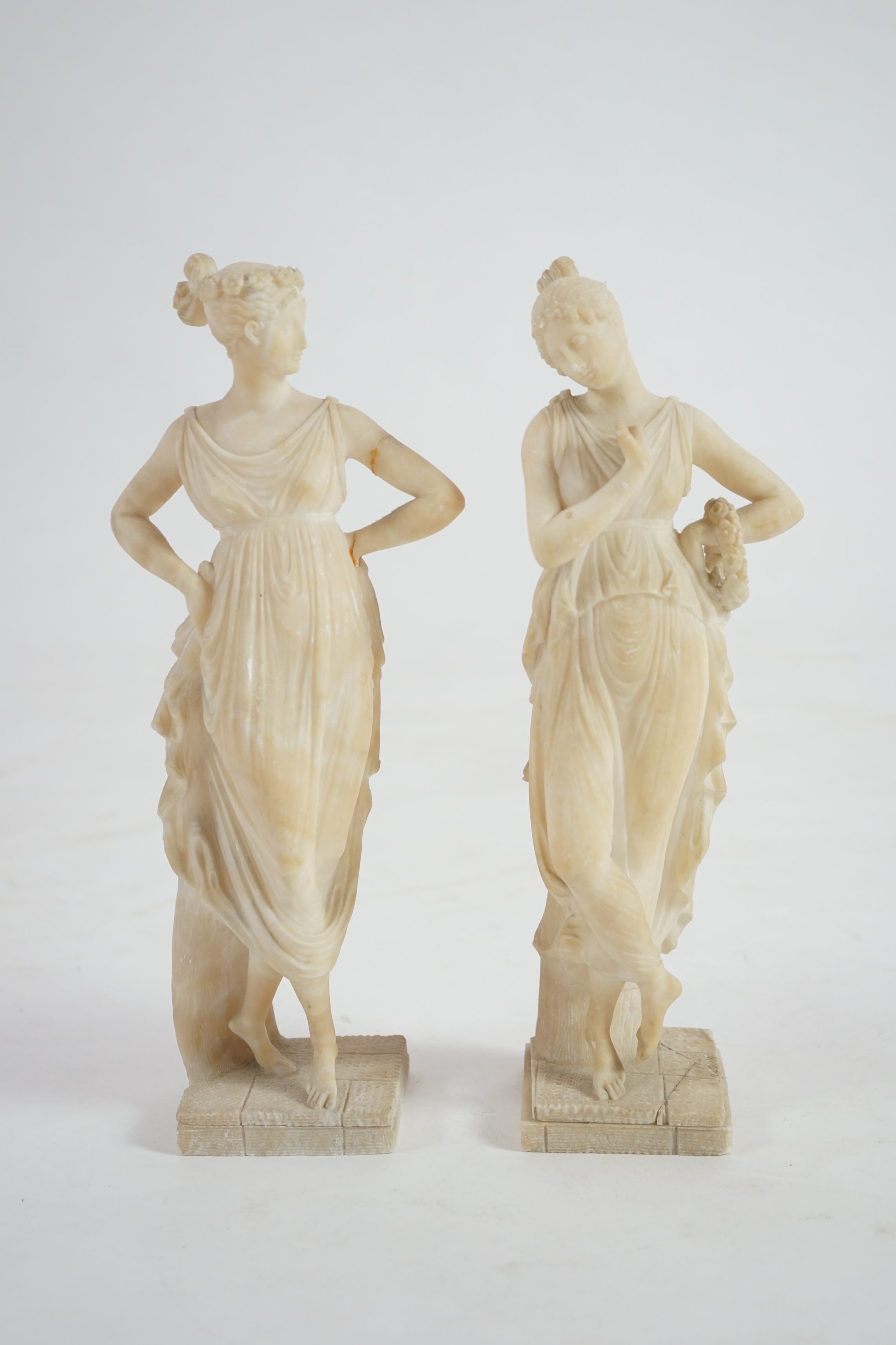 After the antique, a pair of 19th century Italian carved alabaster figures of muses